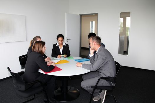 Young professional team in a business meeting sitting at a round table in the office