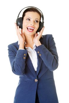 Happy attractive businesswoman listening the music through headphones . Isolated on white.