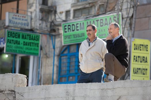 ANKARA, TURKEY ��� APRIL 15: Men having a conversation on a city street on April 15, 2012 in Ankara, Turkey prior to Anzac Day.  Turkish men in cities and villages gather each day to discuss events of the day.