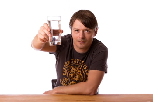 Man sitting at a wooden table with a glass of water. Isolated on a white background