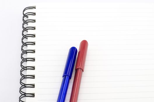 blue and red pen with notebook isolated on white background