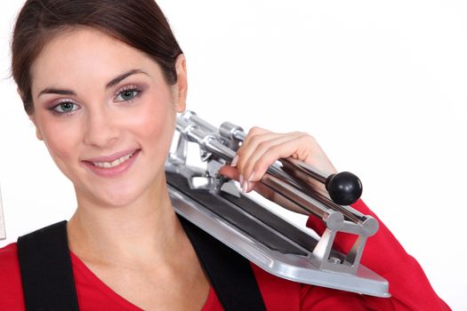 Woman holding tile cutting tool over shoulder