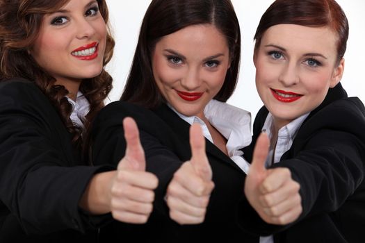 Three corporate women giving the thumbs-up