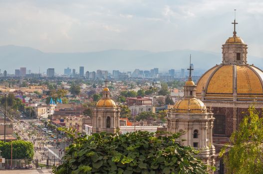 Old Basilica of Guadalupe with Mexico City skyline behind it