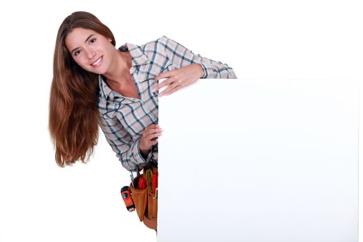 Female carpenter holding white sign for message