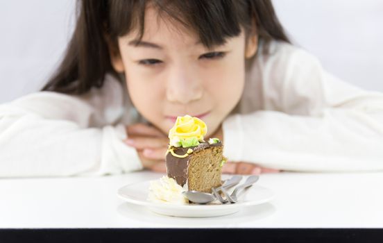 The girl stared cake for overcome by a temptation to eat a slice of a sweet cake