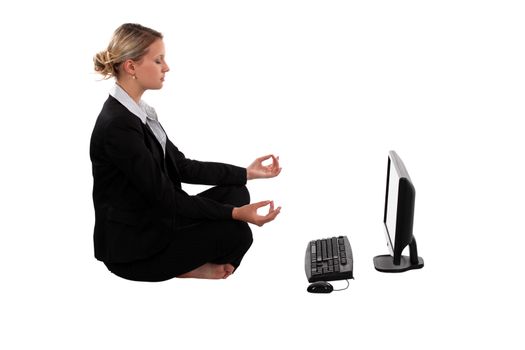 businesswoman meditating in front of her laptop