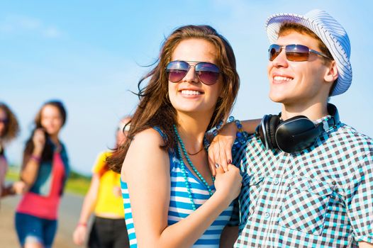 young couple standing on the road, having fun with friends