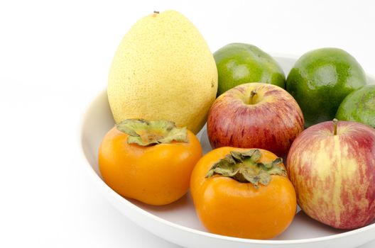 chinese pear apple green orange and persimon on white dish isolated on white background