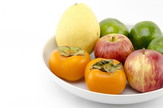 chinese pear apple green orange and persimon on white dish isolated on white background
