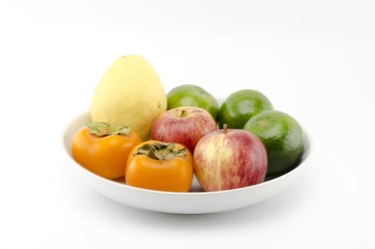 chinese pear apple green orange and persimon on white dish isolated on white background