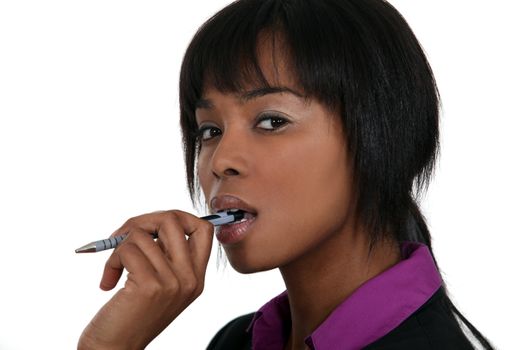 A pensive woman chewing on her pen