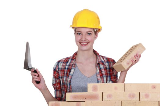 Female mason stood by wall