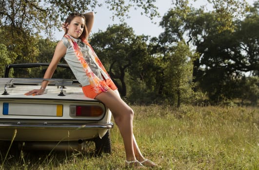 View of a beautiful woman posing on a white convertible car.