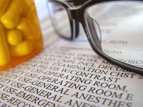 Closeup Of A Medical Hospital Bill, Prescription Medicine And Glasses