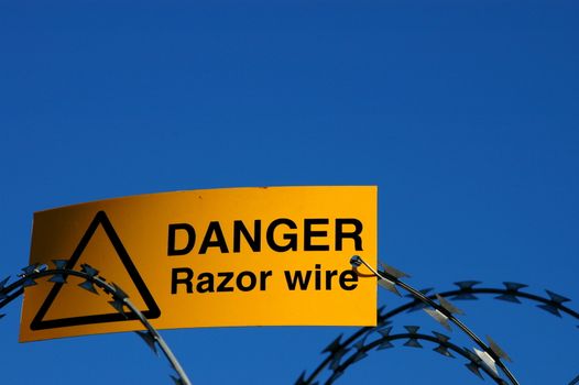 A warning sign on some razor wire