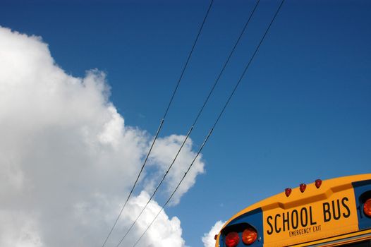 The back of a school bus against a blue sky