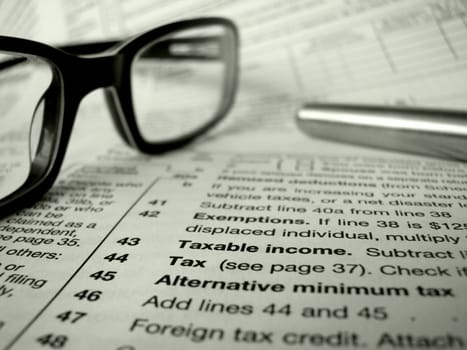 Financial Image Of Some Tax Forms With Glasses And A Pen