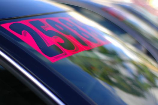 Retail Business Image of Price Stickers on a Row of Used Cars, With Shallow Depth of Focus