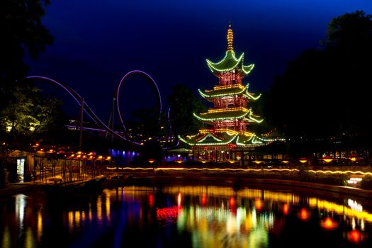 Oriental Pagoda  in Tivoli, Copenhagen, illuminated and reflecting in a pond