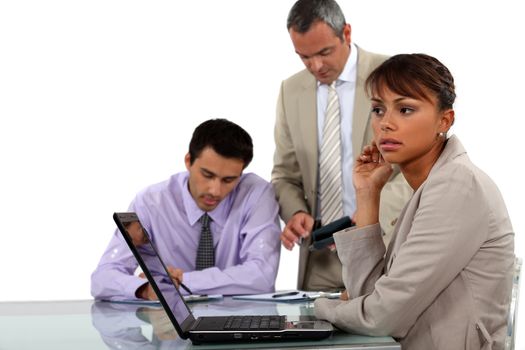 young businesswoman with laptop and male colleagues in background