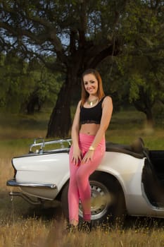 View of a beautiful woman posing on a white convertible car.