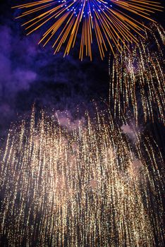 Sparks of a fireworks against dark night sky - class of explosive pyrotechnic devices used for aesthetic and entertainment purposes