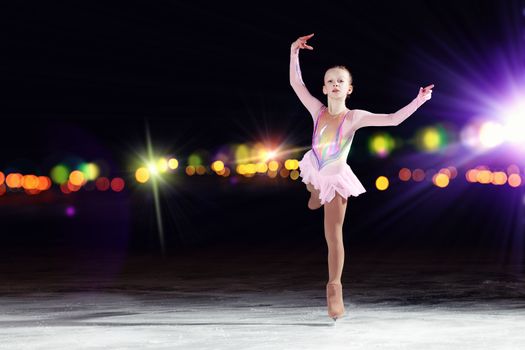 Little girl figure skating at sports arena