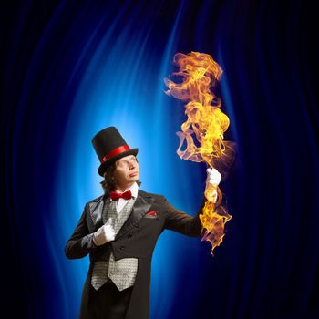 Image of man magician showing trick against color background