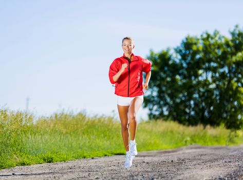 Image of young attractive woman running outdoor