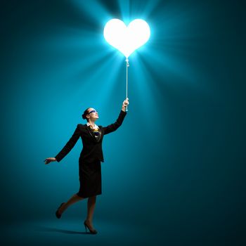 Image of businesswoman holding balloon with heart symbol