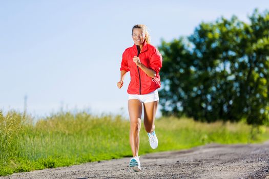 Image of young attractive woman running outdoor