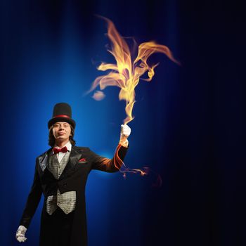 Image of man magician showing trick against color background