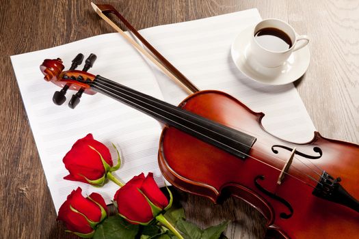 Red roses and a violin on the table