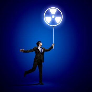 Image of businessman in goggles looking at radioactivity symbol