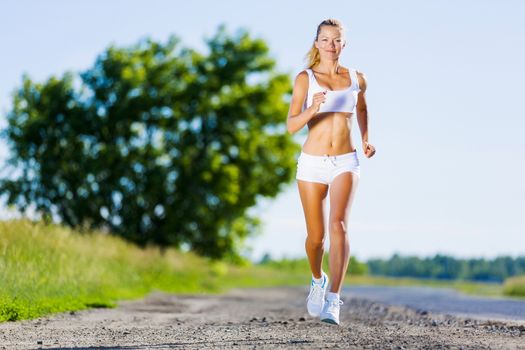 Image of young attractive woman running outdoor