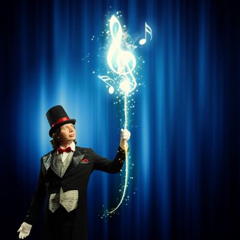 Image of man magician showing trick against color background