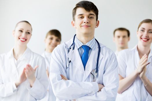 Young doctor in uniform and colleagues at background