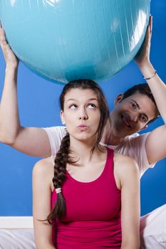 Happy athletic couple with fitness ball.
