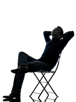 one caucasian man sitting resting looking up  full length in silhouette studio isolated on white background