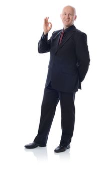 man in suit with happy face gesturing an ok sign isolated on white