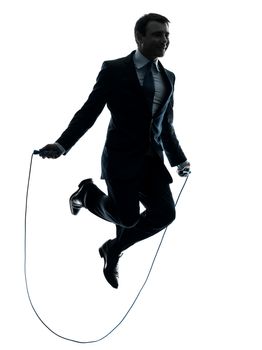 one caucasian businessman exercising jumping rope in silhouette studio isolated on white background