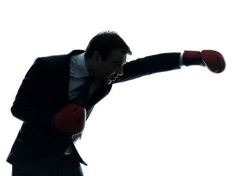 one caucasian businessman with boxing gloves   in silhouette studio isolated on white background