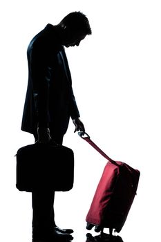 profile one caucasian business traveler man tired with suitcase  full length silhouette in studio isolated white background