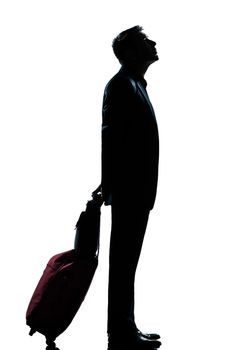 one caucasian man business traveler waiting looking up full length silhouette in studio isolated white background