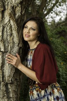 Young beautiful woman with colorful autumn fashionable clothing relaxing on a urban park.