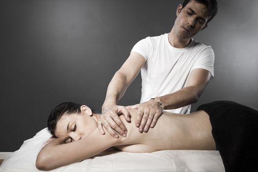 Woman enjoying a wellness back massage in a spa, she is very relaxed