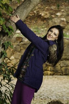 Young beautiful woman with colorful autumn fashionable clothing relaxing on a urban park.