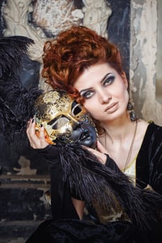 Close-up portrait of red-haired woman holding a mask shot outdoors