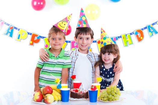 Three adorable kids having fun at birthday party